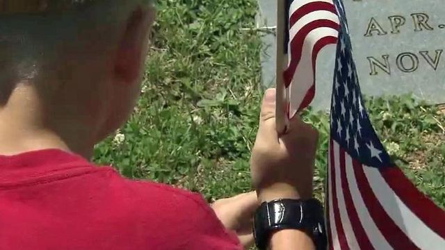 Families make tradition of placing flags on vets' graves