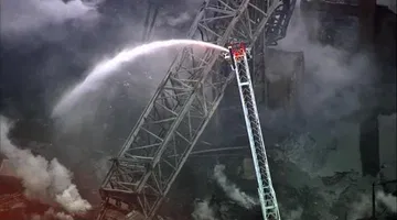 Construction crane collapses in fire, smashes adjacent building