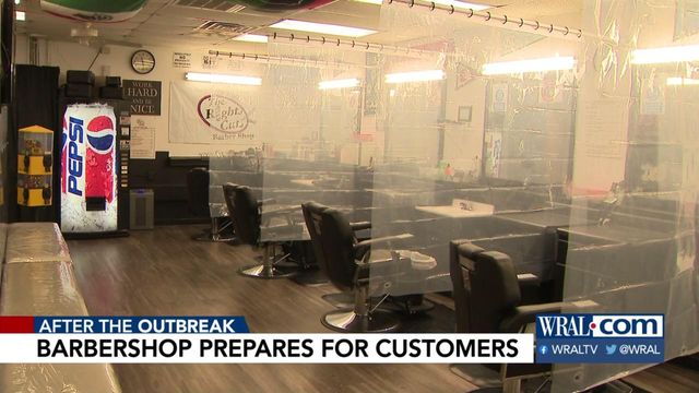Barber shops hang curtains between chairs, prepare to reopen