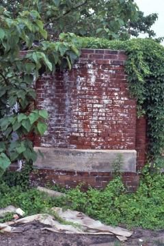The corner stone of the old Raleigh & Gaston roundhouse, hidden in the weeds near Seaboard Station in1986. (Photo courtesy of Brian Ezzelle)