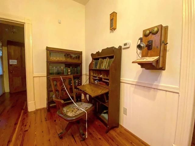 An antique phone hangs on the Pope House's wall.