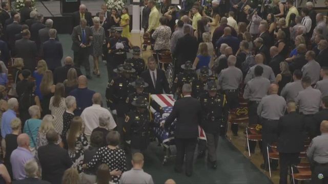 Emotional: Fellow law enforcement officers carry flag-draped casket of fallen Wayne County deputy