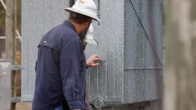 Duke Enegy worker points to a bullet hole in a transformer's radiator at the electric substation in Carthage, North Carolina, on Sunday December 4, 2002. Picture by Jonathan Drake