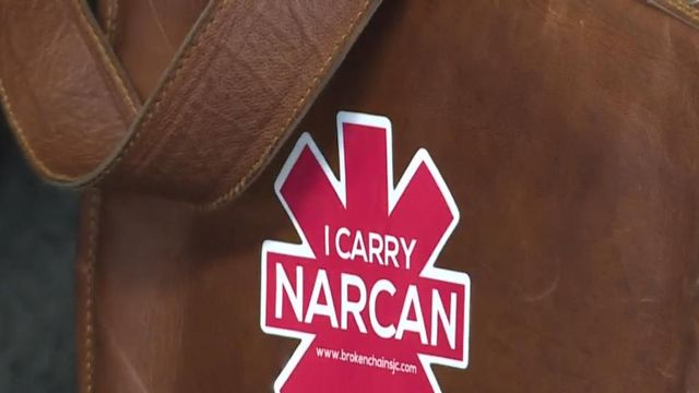 A woman has a 'I Carry Narcan' sticker on her purse in Robeson County on April 24, 2024.