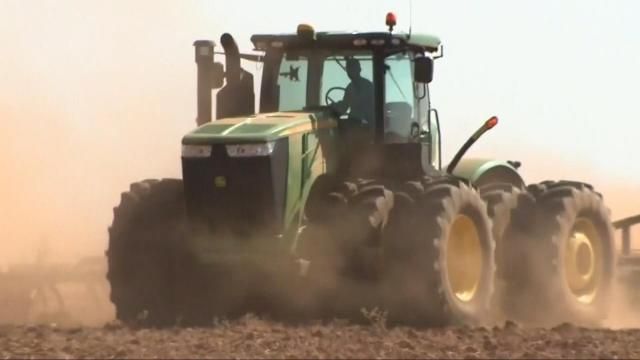 A file photo of a man driving a tractor on a North Carolina farm.