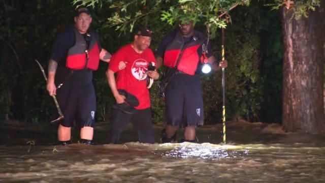 Rescue teams help a man through floodwaters during Tropical Depression Chantal on July 7, 2025.