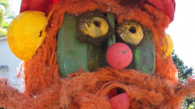 Women using beach trash to decorate Christmas parade float 