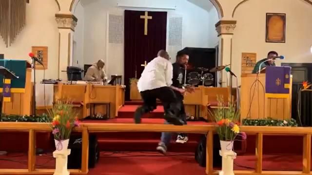 **This photo is for use with this specific article only** Clarence McCallister flies over a railing to tackle a gunman at Jesus’ Dwelling Place Church in North Braddock, Pennsylvania. Mandatory Credit: Glenn Germany/TMX via CNN Newsource.