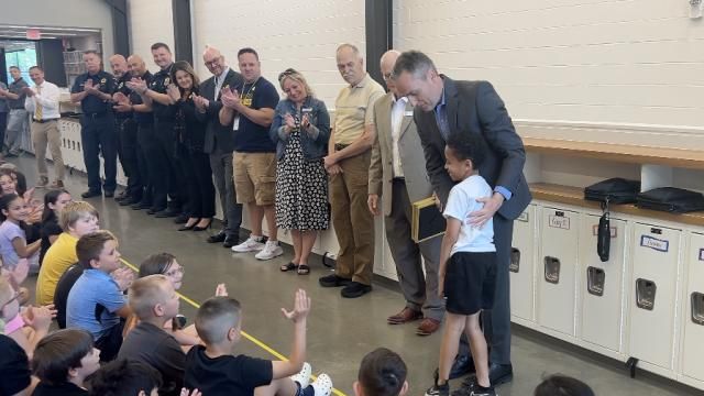 Superintendent Steve Wood congratulates second grader Trey Lewis for alerting others when a classmate had a severe allergic reaction to a granola bar. Mandatory Credit: WEWS via CNN Newsource
Dateline:	TALLMADGE, Ohio. Restriction: Embargo: Cleveland-Akron, OH.