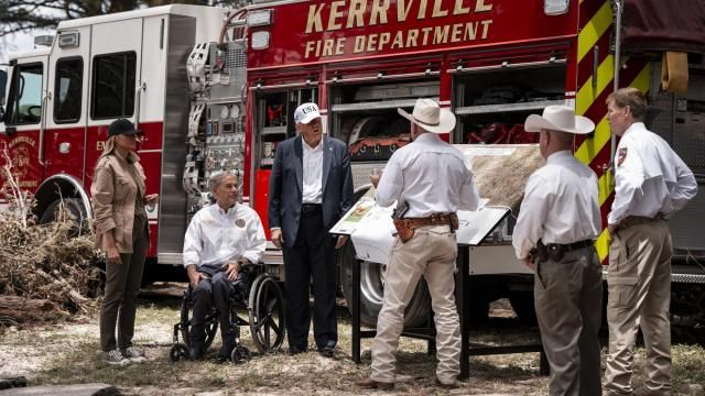 President Donald Trump and First Lady Melania Trump, together with Texas Governor Greg Abbott, get a briefing in Kerrville, Texas, after deadly floods claimed more than 120 lives in the area, July 11, 2025. Texans often draw on the idea of their own self-reliance during times of adversity — Gov. Greg Abbott has used it to deflect tough questions. (Haiyun Jiang/The New York Times)