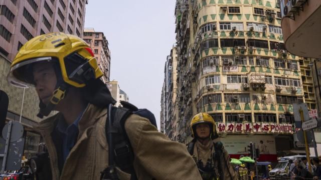 Firefighters walk past a building called New Lucky House where a fire started in Hong Kong, Wednesday, April 10, 2024. (AP Photo/Louise Delmotte) Firefighters walk past a building called New Lucky House where a fire started in Hong Kong, Wednesday, April 10, 2024. (AP Photo/Louise Delmotte)