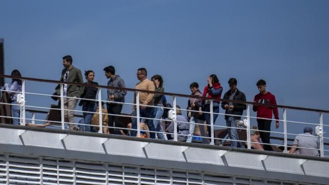 FILE - Passengers are photographed on the cruise ship MSC Armony, moored in the port of Barcelona, Spain, on April 3, 2024. Spain is to deport more than 60 Bolivians who arrived last week by cruise ship in Barcelona but were not allowed to disembark because their visas were false. Spanish government officials said 65 of the 69 Bolivians that arrived would be flown to the Bolivian city of Santa Cruz. (AP Photo/Emilio Morenatti, File)