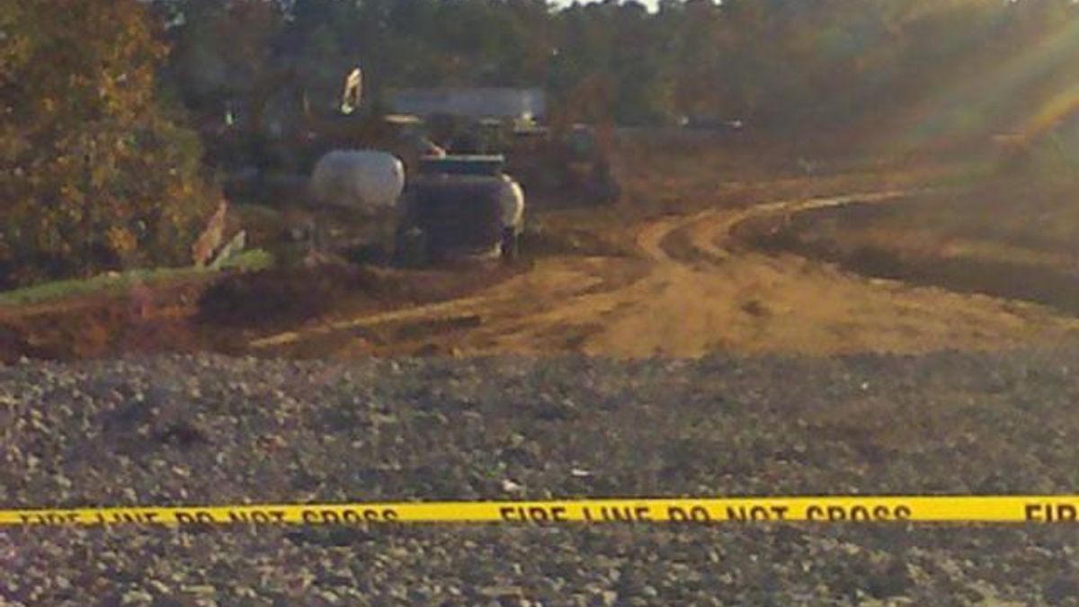 Construction vehicles are behind a fire line after the discovery of landmines at a Fayetteville building site.