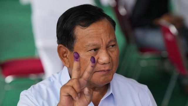 FILE - Indonesian presidential candidate Prabowo Subianto displays a victory symbol after casting his vote in Bojong Koneng, Indonesia, Wednesday, Feb. 14, 2024. Subianto’s rise as Indonesia’s apparent next president is a dramatic comeback from a notorious past, which saw the United States banning his entry over human rights and the Indonesian army, where he led the special forces, expelling him.(AP Photo/Vincent Thian, File) FILE - Indonesian presidential candidate Prabowo Subianto displays a victory symbol after casting his vote in Bojong Koneng, Indonesia, Wednesday, Feb. 14, 2024. Subianto’s rise as Indonesia’s apparent next president is a dramatic comeback from a notorious past, which saw the United States banning his entry over human rights and the Indonesian army, where he led the special forces, expelling him.(AP Photo/Vincent Thian, File)