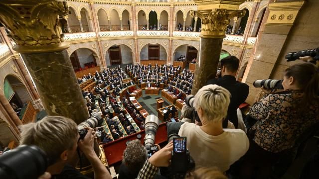 Photographers take pictures as Hungarian Prime Minister Viktor Orban, center right, stands after addressing a parliament session, on the day lawmakers are expected to approve Sweden's accession into NATO, in Budapest, Hungary, Monday, Feb 26, 2024. Hungary's parliament is to vote Monday on ratifying Sweden's bid to join NATO, likely bringing an end to more than 18 months of delays that have frustrated the alliance as it seeks to expand in response to Russia's war in Ukraine. (AP Photo/Denes Erdos) Photographers take pictures as Hungarian Prime Minister Viktor Orban, center right, stands after addressing a parliament session, on the day lawmakers are expected to approve Sweden's accession into NATO, in Budapest, Hungary, Monday, Feb 26, 2024. Hungary's parliament is to vote Monday on ratifying Sweden's bid to join NATO, likely bringing an end to more than 18 months of delays that have frustrated the alliance as it seeks to expand in response to Russia's war in Ukraine. (AP Photo/Denes Erdos)