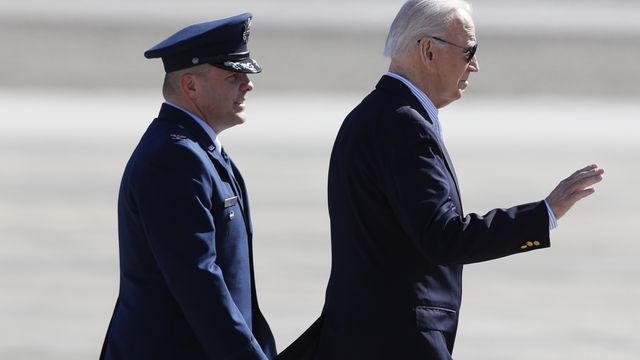 President Joe Biden, escorted by Col. Paul Pawluk, Vice Commander, 89th Airlift Wing, waves before boarding Air Force One, Thursday, Feb. 29, 2024, at Andrews Air Force Base, Md, en route to visit the U.S.- Mexico border in Brownsville, Texas. (AP Photo/Luis M. Alvarez)
