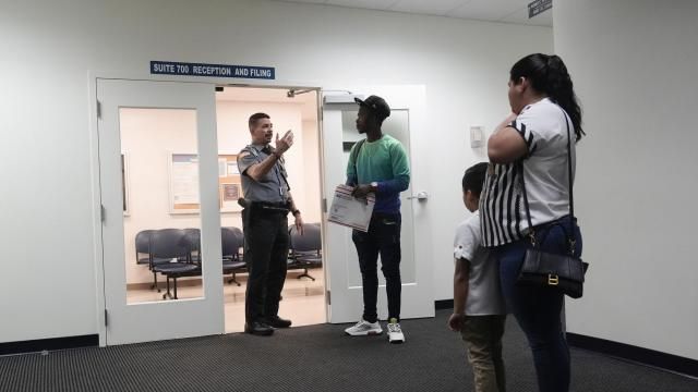 FILE - An officer directs people to a courtroom, Jan. 10, 2024, in an immigration court in Miami. A 53-year-old union of immigration judges has been ordered to get supervisor approval to speak publicly to anyone outside the Justice Department, potentially quieting a frequent critic of heavily backlogged immigration courts in an election year. (AP Photo/Wilfredo Lee, File) FILE - An officer directs people to a courtroom, Jan. 10, 2024, in an immigration court in Miami. A 53-year-old union of immigration judges has been ordered to get supervisor approval to speak publicly to anyone outside the Justice Department, potentially quieting a frequent critic of heavily backlogged immigration courts in an election year. (AP Photo/Wilfredo Lee, File)