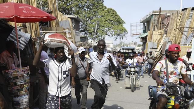 Pedestrians run for cover after hearing gunshots in Port-au-Prince, Haiti, Thursday, March 7, 2024. (AP Photo/Odelyn Joseph) Pedestrians run for cover after hearing gunshots in Port-au-Prince, Haiti, Thursday, March 7, 2024. (AP Photo/Odelyn Joseph)