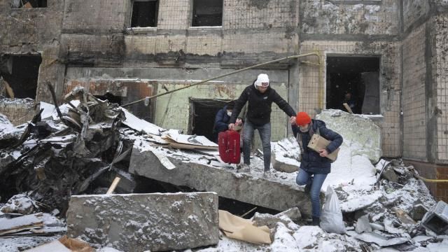 FILE - People walk with belongings out from an apartment building destroyed after Tuesday's Russian attack in Kyiv, Ukraine, Jan. 3, 2024. House Democrats on Tuesday, March 12, 2024, launched a long-shot effort to push $95 billion in aid for Ukraine, Israel and Taiwan to a vote. The move ramps up pressure on House Speaker Mike Johnson to take up the foreign funding package. (AP Photo/Efrem Lukatsky, File) FILE - People walk with belongings out from an apartment building destroyed after Tuesday's Russian attack in Kyiv, Ukraine, Jan. 3, 2024. House Democrats on Tuesday, March 12, 2024, launched a long-shot effort to push $95 billion in aid for Ukraine, Israel and Taiwan to a vote. The move ramps up pressure on House Speaker Mike Johnson to take up the foreign funding package. (AP Photo/Efrem Lukatsky, File)