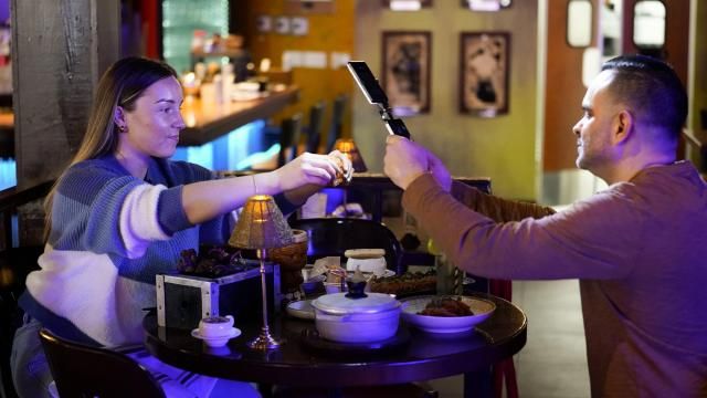 Content creator Jensen Savannah, left, and her fiance and brand manager Jorge Millares, produce a client video at El Puro Cuban Restaurant, Thursday, March 14, 2024, in Charlotte, N.C. (AP Photo/Erik Verduzco) Content creator Jensen Savannah, left, and her fiance and brand manager Jorge Millares, produce a client video at El Puro Cuban Restaurant, Thursday, March 14, 2024, in Charlotte, N.C. (AP Photo/Erik Verduzco)