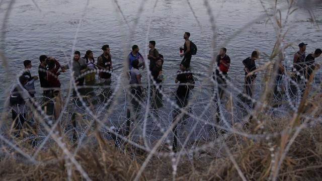 FILE - Migrants wait to climb over concertina wire after they crossed the Rio Grande and entered the U.S. from Mexico, Sept. 23, 2023, in Eagle Pass, Texas. A divided Supreme Court on Tuesday, March 19, 2024, lifted a stay on a Texas law that gives police broad powers to arrest migrants suspected of crossing the border illegally, while a legal battle over immigration authority plays out. (AP Photo/Eric Gay, File) FILE - Migrants wait to climb over concertina wire after they crossed the Rio Grande and entered the U.S. from Mexico, Sept. 23, 2023, in Eagle Pass, Texas. A divided Supreme Court on Tuesday, March 19, 2024, lifted a stay on a Texas law that gives police broad powers to arrest migrants suspected of crossing the border illegally, while a legal battle over immigration authority plays out. (AP Photo/Eric Gay, File)