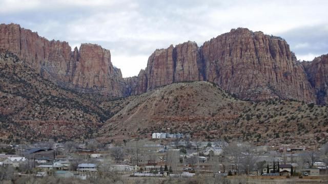 FILE - Hildale, Utah, is pictured sitting at the base of Red Rock Cliff mountains, with its sister city, Colorado City, Ariz., in the foreground on Dec. 16, 2014. On Tuesday, March 19, 2024, a businessman pleaded guilty to conspiring with the leader of an offshoot polygamous sect in the Colorado City-Hildale area to transport underage girls across state lines for sexual activity. The guilty plea by 53-year-old Moroni Johnson marked the first man to be convicted in what authorities say was a scheme to orchestrate sexual acts involving children. (AP Photo/Rick Bowmer, File) FILE - Hildale, Utah, is pictured sitting at the base of Red Rock Cliff mountains, with its sister city, Colorado City, Ariz., in the foreground on Dec. 16, 2014. On Tuesday, March 19, 2024, a businessman pleaded guilty to conspiring with the leader of an offshoot polygamous sect in the Colorado City-Hildale area to transport underage girls across state lines for sexual activity. The guilty plea by 53-year-old Moroni Johnson marked the first man to be convicted in what authorities say was a scheme to orchestrate sexual acts involving children. (AP Photo/Rick Bowmer, File)