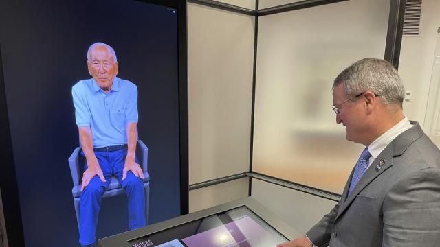 Peter Crean of the National WWII Museum in New Orleans stands at an interactive exhibit with an image of Japanese-American WWII veteran Lawson Ichiro Sakai, who served in the U.S. Army, Tuesday, March 19, 2024. Sakai and 17 other people, including World War II combat veterans, a military nurse, an aircraft factory worker and a USO performer, made extensive video-recordings about their lives and service as part of an interactive exhibit opening at the museum March 20. (AP Photo/Kevin McGill) Peter Crean of the National WWII Museum in New Orleans stands at an interactive exhibit with an image of Japanese-American WWII veteran Lawson Ichiro Sakai, who served in the U.S. Army, Tuesday, March 19, 2024. Sakai and 17 other people, including World War II combat veterans, a military nurse, an aircraft factory worker and a USO performer, made extensive video-recordings about their lives and service as part of an interactive exhibit opening at the museum March 20. (AP Photo/Kevin McGill)