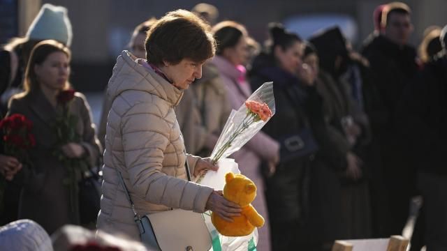 A woman places flowers and a toy at a makeshift memorial in front of the Crocus City Hall on the western outskirts of Moscow, Russia, Monday, March 25, 2024. There were calls Monday for harsh punishment for those behind the attack on the Russia concert hall that killed more than 130 people as authorities combed the burnt-out ruins of the shopping and entertainment complex in search of more bodies. (AP Photo/Alexander Zemlyanichenko) A woman places flowers and a toy at a makeshift memorial in front of the Crocus City Hall on the western outskirts of Moscow, Russia, Monday, March 25, 2024. There were calls Monday for harsh punishment for those behind the attack on the Russia concert hall that killed more than 130 people as authorities combed the burnt-out ruins of the shopping and entertainment complex in search of more bodies. (AP Photo/Alexander Zemlyanichenko)