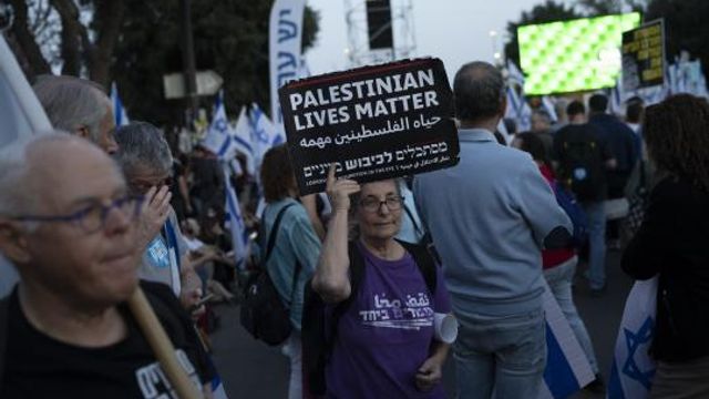 A woman holds up a sign that reads in English 'Palestinians Lives Matter', during a protest against Israeli Prime Minister Benjamin Netanyahu's government and call for the release of hostages held in the Gaza Strip by the Hamas militant group, outside of the Knesset, Israel's parliament, in Jerusalem, Sunday, March 31, 2024. Tens of thousands of Israelis gathered outside the parliament building in Jerusalem on Sunday, calling on the government to reach a deal to free dozens of hostages held by Hamas and to hold early elections. (AP Photo/Leo Correa) A woman holds up a sign that reads in English 'Palestinians Lives Matter', during a protest against Israeli Prime Minister Benjamin Netanyahu's government and call for the release of hostages held in the Gaza Strip by the Hamas militant group, outside of the Knesset, Israel's parliament, in Jerusalem, Sunday, March 31, 2024. Tens of thousands of Israelis gathered outside the parliament building in Jerusalem on Sunday, calling on the government to reach a deal to free dozens of hostages held by Hamas and to hold early elections. (AP Photo/Leo Correa)