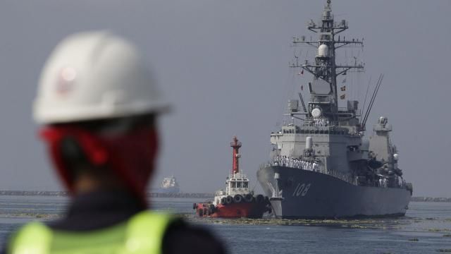 FILE - A Filipino port worker looks as the Japanese Ship Akebono (DD-108), a Murasame-class destroyer of the Japan Maritime Self-Defense Force, prepares to dock for a goodwill visit at Manila's south harbor, Philippines on Sept. 27, 2018. The United States, Japan, Australia and the Philippines will hold their first joint naval exercises, including anti-submarine warfare training, in a show of force Sunday, April 7, 2024 in the South China Sea where Beijing’s aggressive actions to assert its territorial claims have caused alarm. (AP Photo/Aaron Favila, File) FILE - A Filipino port worker looks as the Japanese Ship Akebono (DD-108), a Murasame-class destroyer of the Japan Maritime Self-Defense Force, prepares to dock for a goodwill visit at Manila's south harbor, Philippines on Sept. 27, 2018. The United States, Japan, Australia and the Philippines will hold their first joint naval exercises, including anti-submarine warfare training, in a show of force Sunday, April 7, 2024 in the South China Sea where Beijing’s aggressive actions to assert its territorial claims have caused alarm. (AP Photo/Aaron Favila, File)