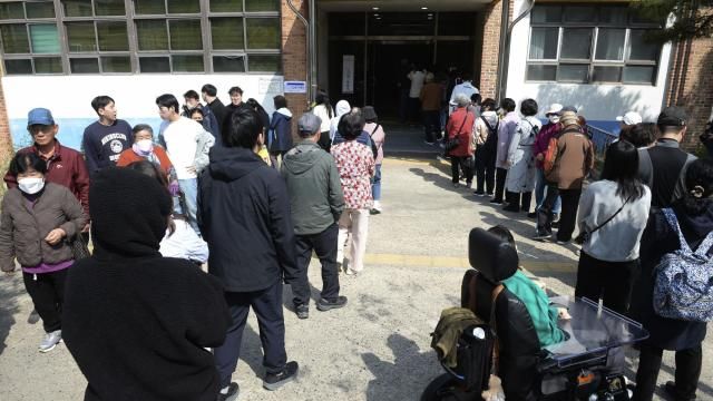 People wait in line to cast their votes for the parliamentary election at a polling station in Ulsan, South Korea, Wednesday, April 10, 2024. South Korean President Yoon Suk Yeol faces a crucial referendum Wednesday in a parliamentary election that could determine whether he becomes a lame duck or enjoys a mandate to pursue key policies for his remaining three years in office. (Bae Byung-soo/Newsis via AP) People wait in line to cast their votes for the parliamentary election at a polling station in Ulsan, South Korea, Wednesday, April 10, 2024. South Korean President Yoon Suk Yeol faces a crucial referendum Wednesday in a parliamentary election that could determine whether he becomes a lame duck or enjoys a mandate to pursue key policies for his remaining three years in office. (Bae Byung-soo/Newsis via AP)