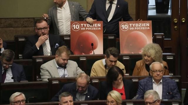 Dariusz Matecki, top right, a conservative lawmaker in the Polish parliament, displays a poster showing a fetus and the words "10th week after conception," during a vote on abortion in Warsaw, Poland, on Friday, April 12, 2024. Polish lawmakers voted Friday to continue work on four proposals that would loosen the law on abortion, a divisive issue in the traditionally Roman Catholic country which has a near-total ban. (AP Photo/Czarek Sokolowski) Dariusz Matecki, top right, a conservative lawmaker in the Polish parliament, displays a poster showing a fetus and the words "10th week after conception," during a vote on abortion in Warsaw, Poland, on Friday, April 12, 2024. Polish lawmakers voted Friday to continue work on four proposals that would loosen the law on abortion, a divisive issue in the traditionally Roman Catholic country which has a near-total ban. (AP Photo/Czarek Sokolowski)