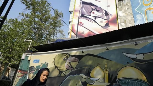A woman walks past an anti-Israeli banner on a building at the Felestin (Palestine) Square in downtown Tehran, Iran, Sunday, April 14, 2024. Israel on Sunday hailed its air defenses in the face of an unprecedented attack by Iran, saying the systems thwarted 99% of the more than 300 drones and missiles launched toward its territory. The sign in Hebrew reads: "Your next mistake will be the end of your fake country." The sign in Farsi reads: "The next slap will be harder." (AP Photo/Vahid Salemi) A woman walks past an anti-Israeli banner on a building at the Felestin (Palestine) Square in downtown Tehran, Iran, Sunday, April 14, 2024. Israel on Sunday hailed its air defenses in the face of an unprecedented attack by Iran, saying the systems thwarted 99% of the more than 300 drones and missiles launched toward its territory. The sign in Hebrew reads: "Your next mistake will be the end of your fake country." The sign in Farsi reads: "The next slap will be harder." (AP Photo/Vahid Salemi)