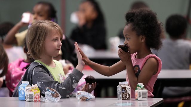 Third grader Katherine Nelson, left, and Shawn Kennedy, kindergarten, talk during breakfast at Williams Science and Arts Magnet school Friday, May 10, 2024, in Topeka, Kan. The school is just a block from the former Monroe school which was at the center of the Brown v. Board of Education Supreme Court ruling ending segregation in public schools 70 years ago. (AP Photo/Charlie Riedel)