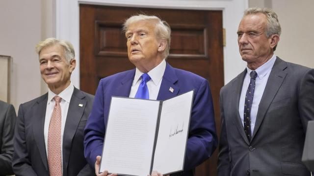 President Donald Trump, with Dr. Mehmet Oz, Administrator of the Centers for Medicare &amp; Medicaid Services, left, and Health and Human Services Secretary Robert F. Kennedy Jr., right, holds an executive order related to drug prices, in the Roosevelt Room of the White House in Washington, Monday, May 12, 2025, in Washington. (AP Photo/Mark Schiefelbein)