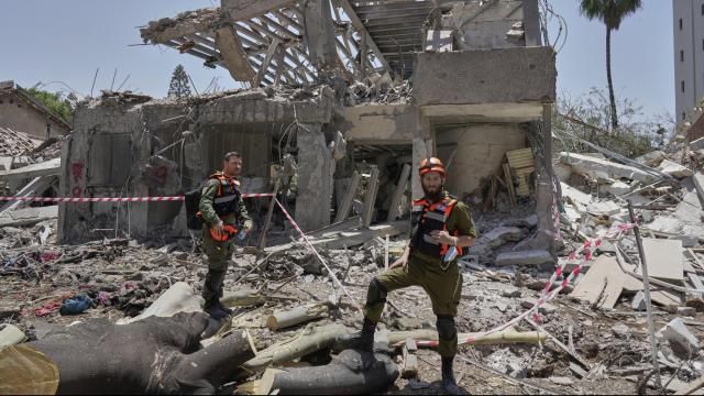 Israeli soldiers inspect the site struck by a direct missile strike launched from Iran in Tel Aviv, Israel, on Sunday, June 22, 2025. (AP Photo/Bernat Armangue)