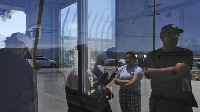 People wait outside of Glass House Farms, a day after an immigration raid on the facility, Friday, July 11, 2025, in Camarillo, Calif. (AP Photo/Jae C. Hong)