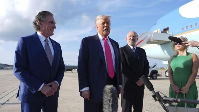 President Donald Trump speaks to the media after arriving at Joint Base Andrews, Tuesday, July 15, 2025, in Joint Base Andrews, Md., as Secretary of the Interior Doug Burgum, left, Secretary of Commerce Howard Lutnick and White House Press Secretary Karoline Leavitt, right, look on. (AP Photo/Evan Vucci)