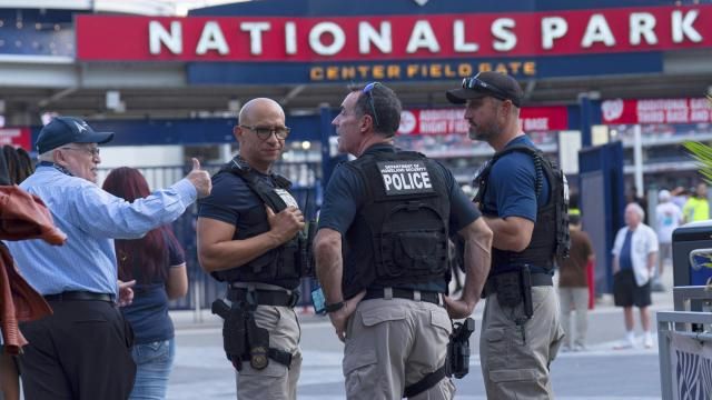 Department of Homeland Security police officers interact with people arriving at Nationals Park during a baseball game between the Washington Nationals and Philadelphia Phillies in Washington, Thursday, Aug. 14, 2025. (AP Photo/Jose Luis Magana)
