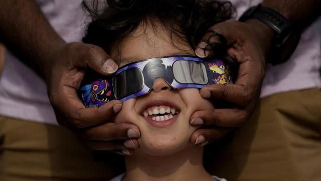 FILE - Viewers use special glasses to watch from San Antonio, as the moon moves in front of the sun during an annular solar eclipse, or ring of fire, Oct. 14, 2023. The total solar eclipse on April 8, 2024 may be weeks away but businesses are ready for the celestial event with oodles of special eclipse glasses for sale, along with T-shirts and other souvenirs. (AP Photo/Eric Gay, File) FILE - Viewers use special glasses to watch from San Antonio, as the moon moves in front of the sun during an annular solar eclipse, or ring of fire, Oct. 14, 2023. The total solar eclipse on April 8, 2024 may be weeks away but businesses are ready for the celestial event with oodles of special eclipse glasses for sale, along with T-shirts and other souvenirs. (AP Photo/Eric Gay, File)