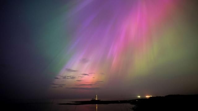 The aurora borealis, also known as the northern lights, glow on the horizon at St. Mary's Lighthouse in Whitley Bay on the North East coast, England, Friday, May 10, 2024. Brilliant purple, green, yellow and pink hues of the Northern Lights were reported worldwide, with sightings in Germany, Switzerland, London, and the United States and Canada. (Owen Humphreys/PA via AP)