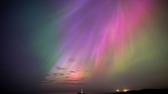 The aurora borealis, also known as the northern lights, glow on the horizon at St. Mary's Lighthouse in Whitley Bay on the North East coast, England, Friday, May 10, 2024. Brilliant purple, green, yellow and pink hues of the Northern Lights were reported worldwide, with sightings in Germany, Switzerland, London, and the United States and Canada. (Owen Humphreys/PA via AP)