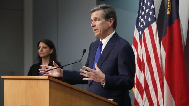 North Carolina Gov. Roy Cooper answers a question during a briefing on the coronavirus pandemic at the Joint Force Headquarters in Raleigh on May 20, 2020, as N.C. Department of Health and Human Services Secretary Mandy Cohen looks on (Photo courtesy N.C. Department of Public Safety