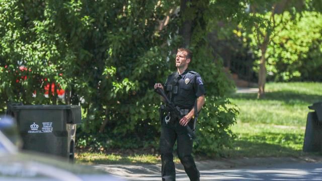 A Charlotte Mecklenburg police officer carries a gun as he walks in the neighborhood where an officer-involved shooting took place in Charlotte, N.C., Monday, April 29, 2024. Police in North Carolina say numerous law enforcement officers conducting a task force operation have been struck by gunfire in Charlotte. (AP Photo/Nell Redmond)