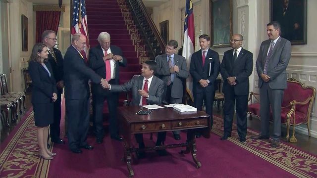 McCrory dismisses critics in signing state budget