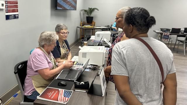 Lee County poll workers Millie Johnson, left, and Melanie Underwood check photo identification of voters during the 2023 Sanford municipal election, using North Carolina's new voter ID rules.