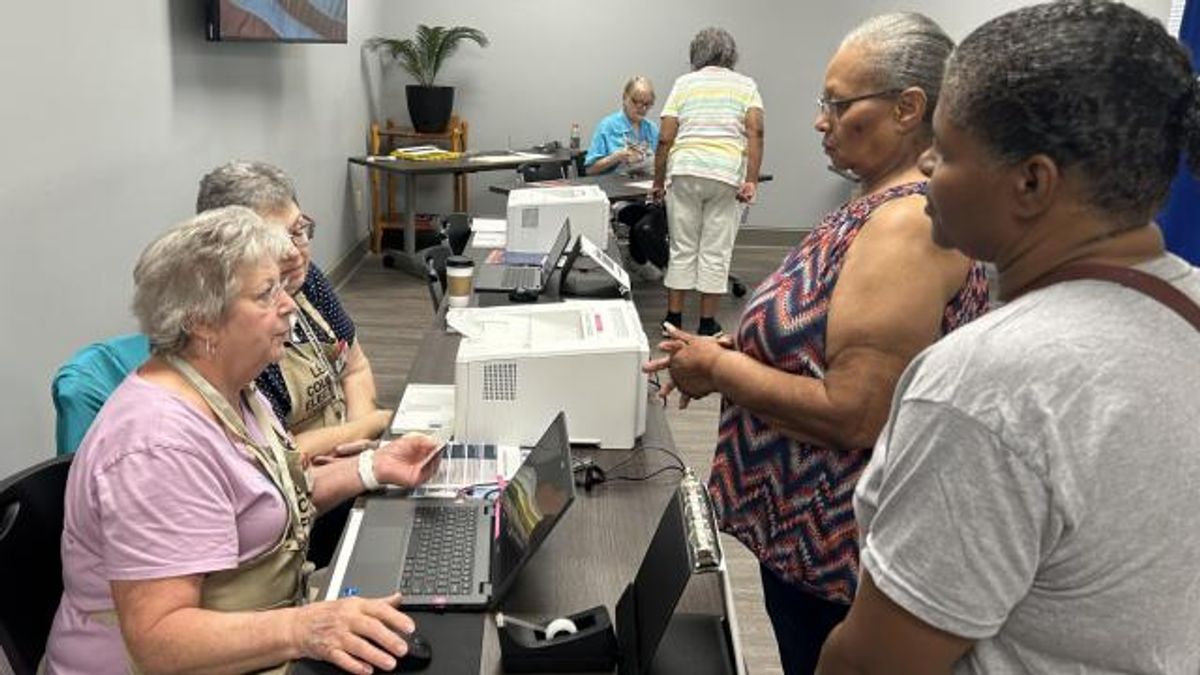 Lee County poll workers Millie Johnson, left, and Melanie Underwood check photo identification of voters during the 2023 Sanford municipal election, using North Carolina's new voter ID rules.