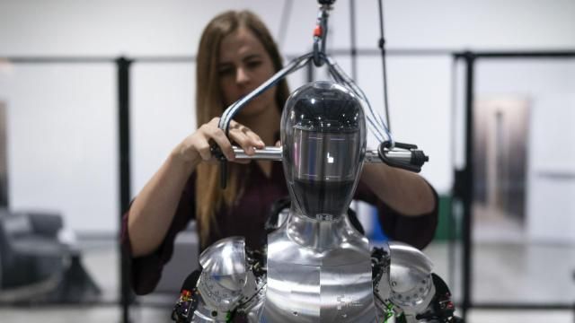 FILE - AI engineer Jenna Reher works on humanoid robot Figure 01 at Figure AI's test facility in Sunnyvale, Calif., Oct. 3, 2023. ChatGPT-maker OpenAI is looking to fuse its artificial intelligence systems into the bodies of humanoid robots as part of a new deal with robotics startup Figure. Sunnyvale, California-based Figure announced the partnership Thursday, Feb. 29, 2024, along with $675 million in venture capital funding from a group that includes Amazon founder Jeff Bezos as well as Microsoft, chipmaker Nvidia and the startup-funding divisions of Amazon, Intel and OpenAI. (AP Photo/Jae C. Hong, File) FILE - AI engineer Jenna Reher works on humanoid robot Figure 01 at Figure AI's test facility in Sunnyvale, Calif., Oct. 3, 2023. ChatGPT-maker OpenAI is looking to fuse its artificial intelligence systems into the bodies of humanoid robots as part of a new deal with robotics startup Figure. Sunnyvale, California-based Figure announced the partnership Thursday, Feb. 29, 2024, along with $675 million in venture capital funding from a group that includes Amazon founder Jeff Bezos as well as Microsoft, chipmaker Nvidia and the startup-funding divisions of Amazon, Intel and OpenAI. (AP Photo/Jae C. Hong, File)