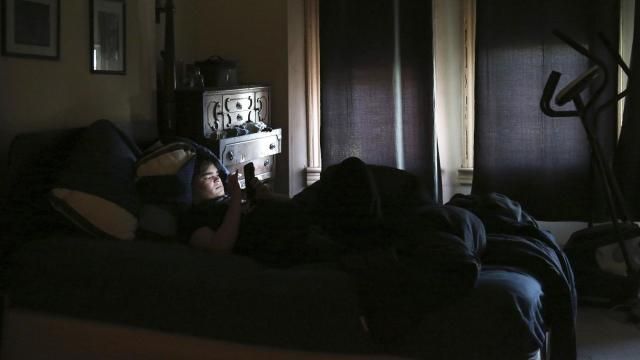 FILE - James Walter uses a phone at home in the Queens borough of New York, on April 7, 2021. Sleep scientists long ago established that insufficient sleep is linked with poor health outcomes, anxiety, obesity and several other negative effects. The research is equally conclusive that smartphones are particularly disruptive to the circadian clock that regulates sleep and other hormones. (AP Photo/Jessie Wardarski, File) FILE - James Walter uses a phone at home in the Queens borough of New York, on April 7, 2021. Sleep scientists long ago established that insufficient sleep is linked with poor health outcomes, anxiety, obesity and several other negative effects. The research is equally conclusive that smartphones are particularly disruptive to the circadian clock that regulates sleep and other hormones. (AP Photo/Jessie Wardarski, File)