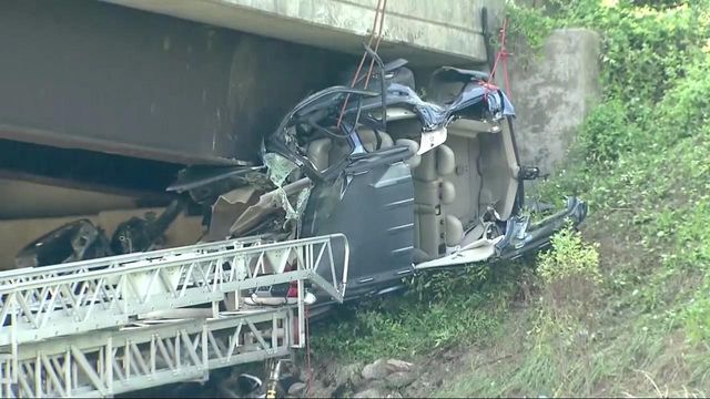 Officials work to rescue car trapped under I-40 bridge